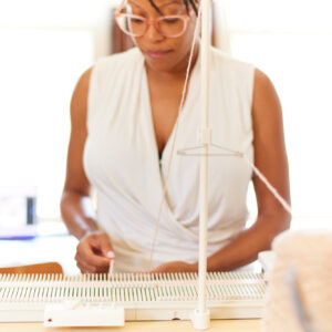 African American woman using a knitting machine