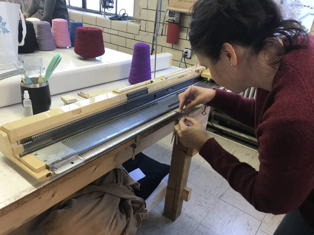 student machine knitting during a class